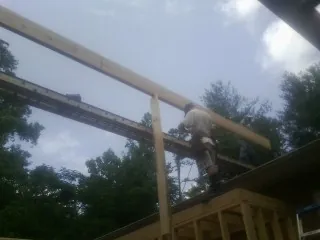 Carpenter setting a ridge beam over a new addition frame — Ice Dam Removal by Roofing Brothers in Pershing