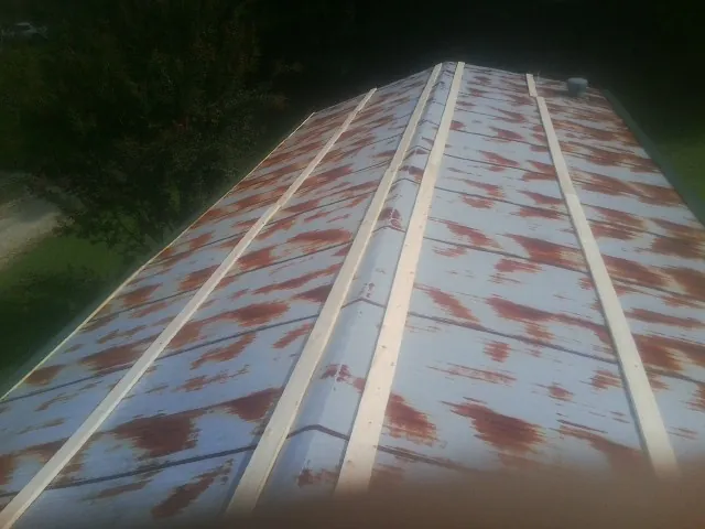 Rusted metal roof panels with new wood purlins before replacement — Storm Damage Roof Repair in Pershing by Roofing Brothers